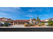 Single-story home with a two-car garage and landscaped front yard at 1408 Dolomiti Dr, Las Vegas, NV 89117