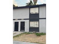 Two-unit building with gray siding, private entrances, and small yards at 3535 Mercury St # E, North Las Vegas, NV 89030