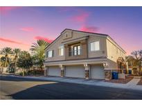 Tan three-car garage home with balcony and desert landscaping at 6624 Lavender Lilly Ln # 1, North Las Vegas, NV 89084