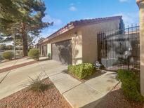 Spanish style home with attached two-car garage and wrought iron gate at 1858 Camino Verde Ln, Las Vegas, NV 89119