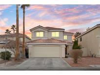 Two-story house with beige exterior, attached garage, and landscaping at 5183 Zoroaster St, Las Vegas, NV 89148