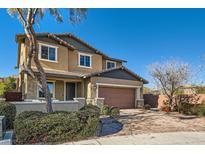 Two-story house with tan siding, brown garage door, and landscaped yard at 5873 Skyfall Ct, Las Vegas, NV 89135