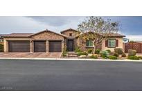 Beautiful stone house with three-car garage and nicely landscaped front yard at 8351 Agave Bloom St, Las Vegas, NV 89131