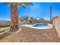 Inviting backyard with a sparkling pool, grassy area, and mature palm tree at 4389 Bluecrest Rd, Las Vegas, NV 89121