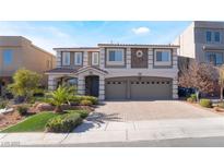 Two-story house with gray siding, stone accents, and a three-car garage at 9883 Russian Hill St, Las Vegas, NV 89141