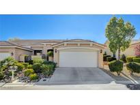 Tan two-story home with attached garage and landscaped front yard at 10563 Premia Pl, Las Vegas, NV 89135