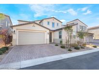 Two-story house with a beige facade, three-car garage, and landscaped front yard at 19 Cresta Villa Ct, Henderson, NV 89011