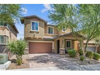 Two-story house with brown garage door and landscaping at 10554 Cloud Whisper Dr, Las Vegas, NV 89135