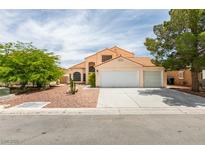 Two-story house with a three-car garage and landscaped front yard at 4516 Ryder Ln, North Las Vegas, NV 89031