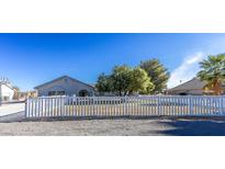 Ranch style home with white picket fence, mature tree, and spacious yard at 2440 Robison Farm Rd, Logandale, NV 89021