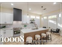 Modern kitchen with white cabinets, quartz countertops, and island at 10008 Hope Island Dr, Las Vegas, NV 89134