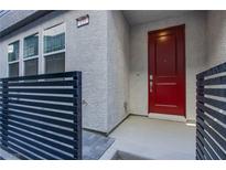 Modern home's exterior features a red front door and sleek black fence at 139 Aqua Commons Ln, Henderson, NV 89015