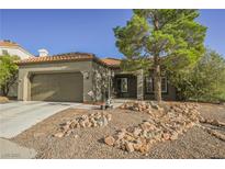 Single-story house with a two-car garage and desert landscaping at 1424 Country Hollow Dr, Las Vegas, NV 89117