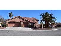 One-story house with two-car garage, landscaped yard, and palm trees at 5500 Bayfield St, Las Vegas, NV 89149