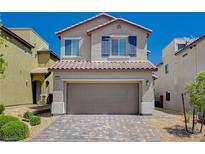 Two-story house with taupe exterior, gray garage door, and landscaped yard at 8284 Southern Cross Ave, Las Vegas, NV 89131