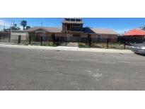 Ranch style home with a large front yard and black metal fence at 130 Palm Ln, Las Vegas, NV 89101