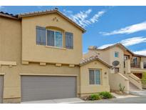 Tan two-story house with gray garage door and satellite dish at 1132 Via Fellini, Henderson, NV 89052