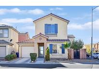 Two-story house with tan siding, blue shutters, and a landscaped front yard at 5515 Gold Mint Ln, Las Vegas, NV 89122