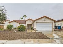 One-story house with a tile roof, attached garage, and landscaped yard at 5041 Vista Del Rancho Way, North Las Vegas, NV 89031